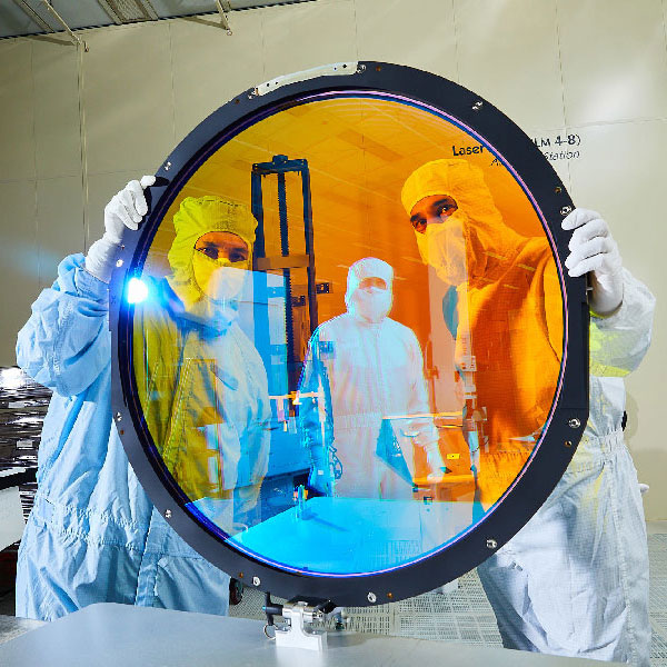 LLNL optical engineers look through the “r” filter designed for a telescope at the Vera C. Rubin Observatory