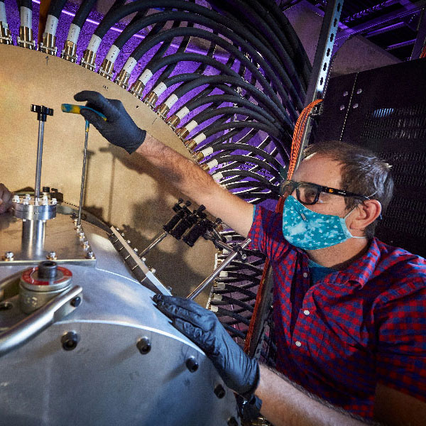 A technician makes an adjustment to MJOLNIR, LLNL’s dense plasma focus