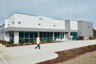 The exterior of LLNL’s Advanced Manufacturing Laboratory (AML) with a person walking in the foreground.